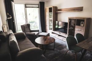 a living room with a couch and chairs and a television at Unterkunft im Herzen von Berlin in Berlin