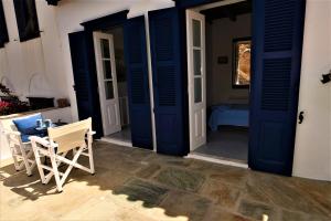 a porch with blue doors and a table and chairs at Villa Sunset Hydra in Hydra
