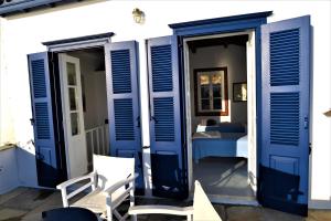 a room with blue doors and a bedroom at Villa Sunset Hydra in Hydra