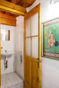 a bathroom with a sink and a wooden door at La Casa de Alicia in Salobreña