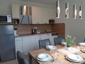 博希尼的住宿－Apartments Vila Darja，厨房配有带盘子和酒杯的桌子