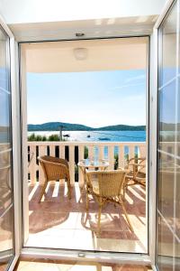 a balcony with a table and chairs and a view of the water at Villa Magica in Pirovac