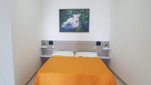 ペスキチにあるResidence Nido Verdeのベッドルーム1室(オレンジ色のベッドカバー付)