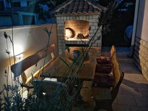 un patio con un horno de ladrillo con banco y chimenea en Apartmani Lucija, en Zadar