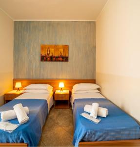 a room with two beds with towels on them at Bed & breakfast Tre Palme in Raffadali