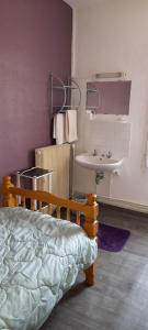 - une chambre avec un lit et un lavabo dans l'établissement Le Parisien, à Saintes