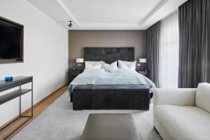 een slaapkamer met een groot bed en een bank bij Margarethenhof am Tegernsee in Waakirchen