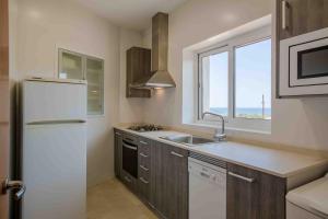 cocina con nevera blanca y fregadero en Creixell Sea Views, en Creixell