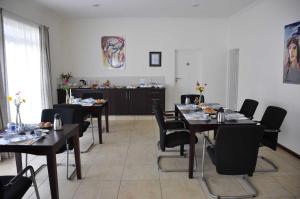 un comedor con mesas y sillas negras en Amohela Guesthouse, en Midrand