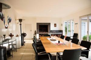 una sala da pranzo con tavolo, sedie e camino di Amohela Guesthouse a Midrand