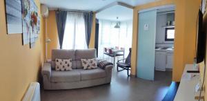 a living room with a chair and a kitchen at El Balconcito de San Millan II in Segovia