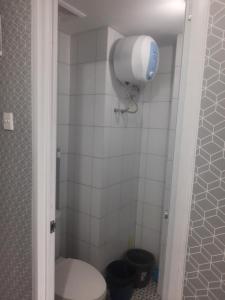 ein Badezimmer mit einem WC und einem Haartrockner an der Wand in der Unterkunft Apartement emerald bintaro 2 in Pondokaren