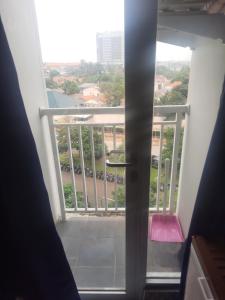 a view of a balcony from a room with a door at Apartement emerald bintaro 2 in Pondokaren