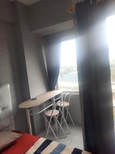 Zimmer mit einem Tisch, 2 Stühlen und einem Fenster in der Unterkunft Apartement emerald bintaro 2 in Pondokaren