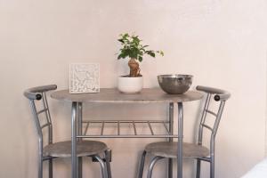 une table avec deux chaises et une plante sur celle-ci dans l'établissement Suite Vico li cuti, à Catane