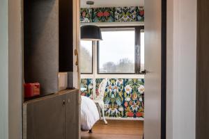 1 dormitorio con ventana y 1 cama con cortina en SWEETS - Meeuwenpleinbrug, en Ámsterdam