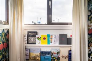 a book shelf with books on it with a window at SWEETS - Meeuwenpleinbrug in Amsterdam