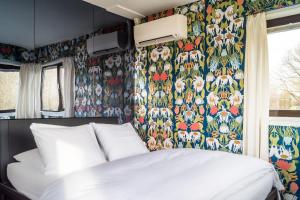 a bedroom with a bed and a floral wallpaper at SWEETS - Meeuwenpleinbrug in Amsterdam