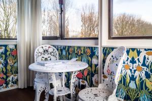 a table and two chairs in a room with floral wallpaper at SWEETS - Meeuwenpleinbrug in Amsterdam