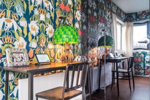 a dining room with a table with chairs and a floral wallpaper at SWEETS - Meeuwenpleinbrug in Amsterdam
