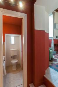 bagno con servizi igienici e pareti rosse di B&B Arena di Lucca a Lucca