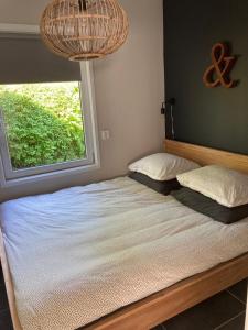 1 dormitorio con 1 cama grande y ventana en Klein geluk en Warmenhuizen