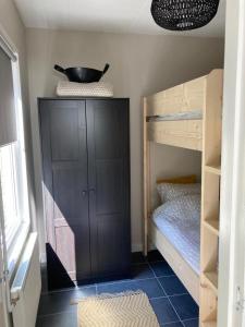 WarmenhuizenにあるKlein gelukの二段ベッド2台、棚の上にボウルが備わる客室です。