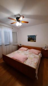 Schlafzimmer mit einem Bett und einem Deckenventilator in der Unterkunft Apartment PinoAppLosinj in Veli Lošinj