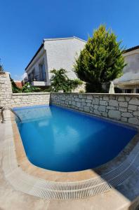 a swimming pool in front of a stone wall at Mavi Konak Alaçatı in Alacati