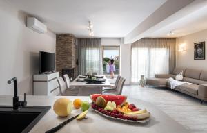 a kitchen and living room with a bowl of fruit on a table at Villa Sara in Nikiti