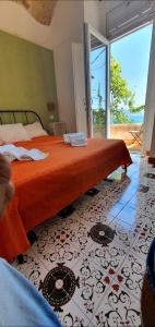 a bedroom with a bed with an orange blanket at B&B FISH in Vietri sul Mare