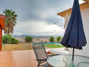 une terrasse avec une table en verre et un parasol dans l'établissement Tranquil Holiday Home in Albox with shared pool, à Albox