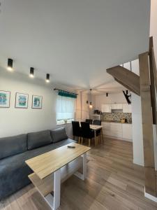 a living room with a couch and a table at Marina Domki Apartamentowe in Jastarnia