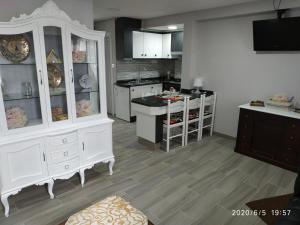 a large kitchen with white cabinets and a counter at Apartamento Laxe con vistas al mar in Laxe