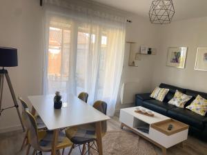 a living room with a white table and a couch at Cottage l'Echappée Belle in Saint-Amand-les-Eaux