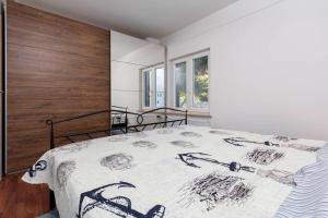 a bedroom with a bed with a black and white comforter at Apartman Milan in Banjole +22 photos