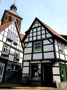 um edifício preto e branco com uma torre de relógio em Das Nachtwächterhäuschen em Tecklenburg