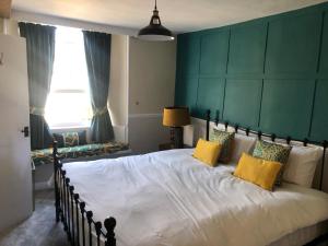 a bedroom with a large white bed with yellow pillows at The Black Bull Inn in Middleham