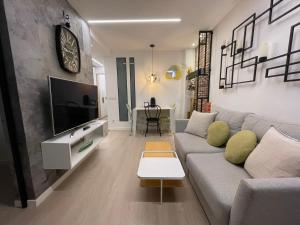 a living room with a couch and a tv at Oktheway Gran Via in Sarria