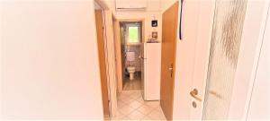 an open door to a bathroom with a toilet at Guest House Jasna in Novalja