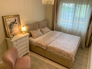 a bedroom with a bed with a dresser and a window at Central Luxury Apartment in Alba Iulia
