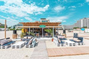a group of chairs and tables on a beach at Beach Rooms Roberta in Mamaia