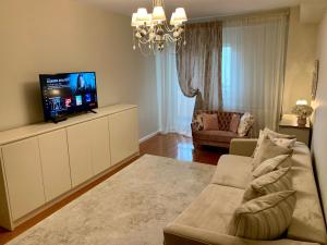 a living room with a couch and a flat screen tv at Central Luxury Apartment in Alba Iulia