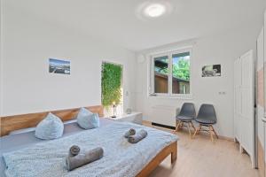 um quarto com uma cama grande e 2 cadeiras cinzentas em TTP 13 Gartenoase beim Wassertürmchen Immenstaad em Immenstaad am Bodensee