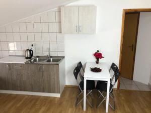 cocina con mesa, sillas y fregadero en Pansion Modana Medjugorje, en Međugorje