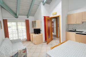 a living room with a bed and a kitchen at Casa Azzurra in Pozza di Fassa