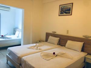 a hotel room with two beds with bows on them at Flisvos Rooms in Frangokastello