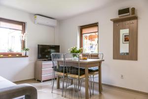 a dining room with a table and chairs and a tv at Domek letniskowy Słowiańska 15 in Giżycko