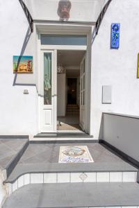 una puerta delantera de una casa con un cartel en el suelo en Holidays Perla d'Amalfi, en Amalfi