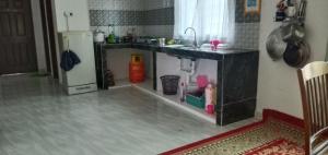 cocina con fregadero y nevera en Nurul Saadah Lunas, en Lunas